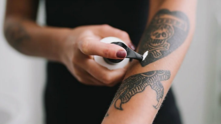 An image of a person receiving tattoo removal treatment using numbing creams and cold air